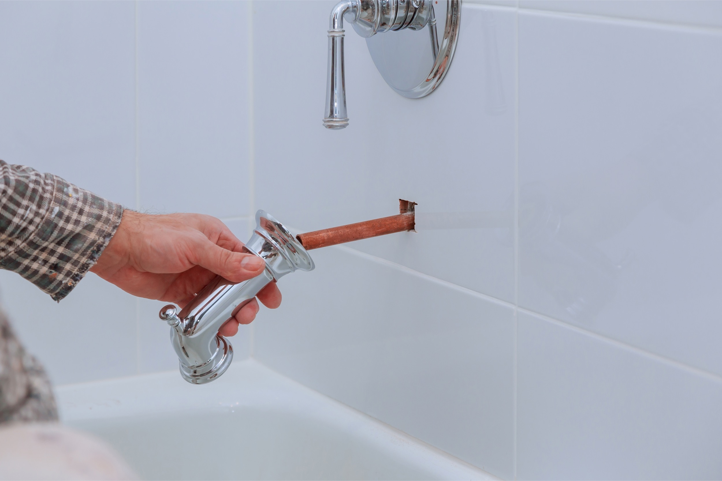 Expert plumber working on shower system